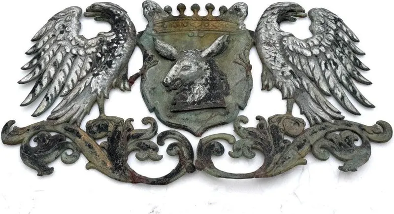 Großes Wappen aus getriebenem Metall, gekrönter Eselskopf mit Adlern als Schildhaltern