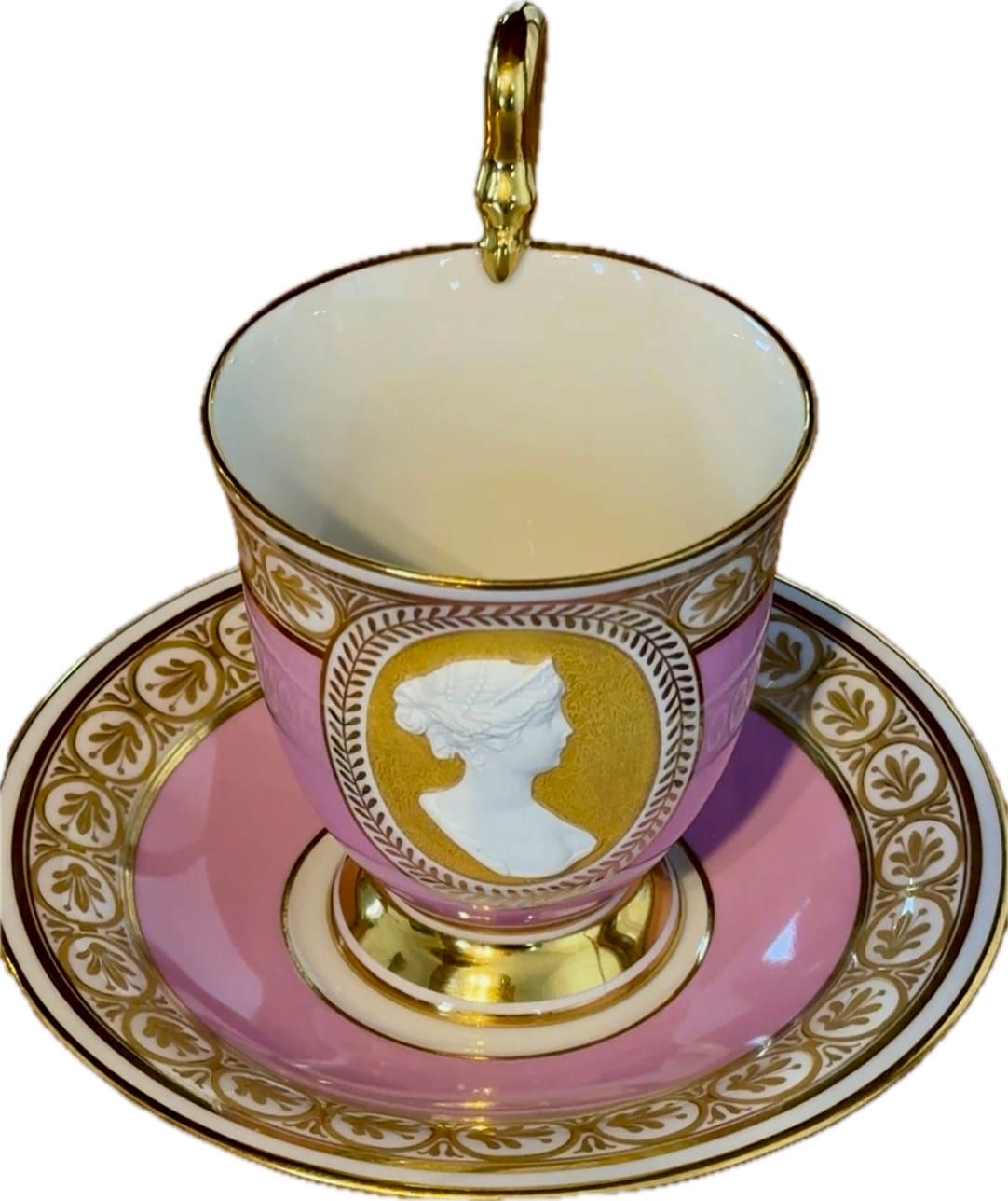 Antike Porträttasse mit Untertasse (sogenannte Königin-Luise-Tasse) der Königlichen Porzellan-Manufaktur Berlin (KPM), verziert mit einem rosa Fond und einem Reliefporträt.